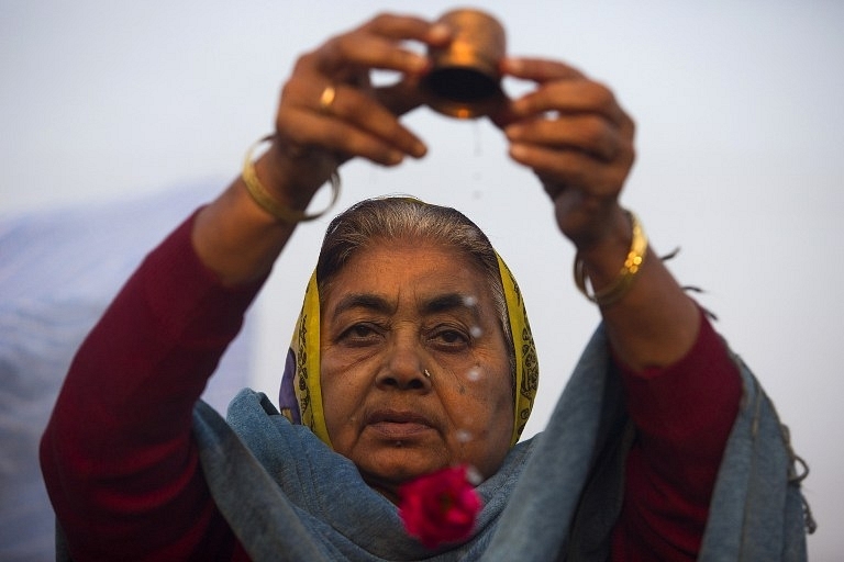 Making an offering at the Kumbh. (AFP PHOTO/ Andrew Caballero-Reynolds)