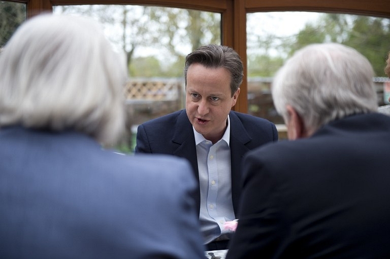 British Prime Minister and leader of the Conservative Party David Cameron (C) AFP PHOTO / POOL / OLI SCARFF