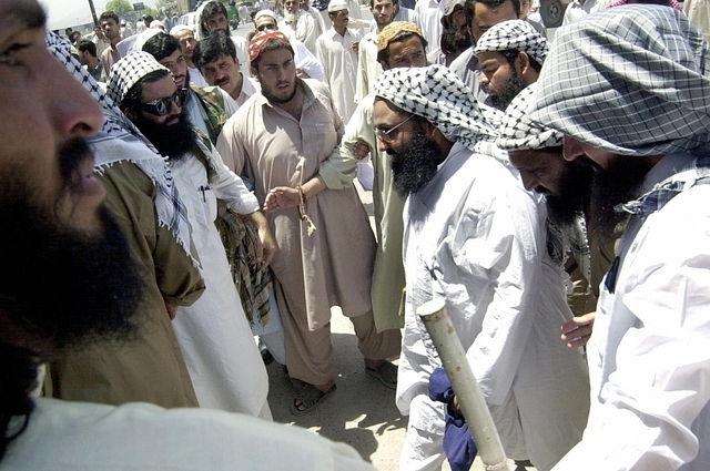 Maulana Masood Azhar (3rd R), head of an outlawed militant organization of Jaish-e-Mohammad makes his way towards a mosque in Peshawar. Azhar’s terror outfit has been linked to the recent Pathankot attacks. (Photo credit: TARIQ MAHMOOD/AFP/Getty Images)