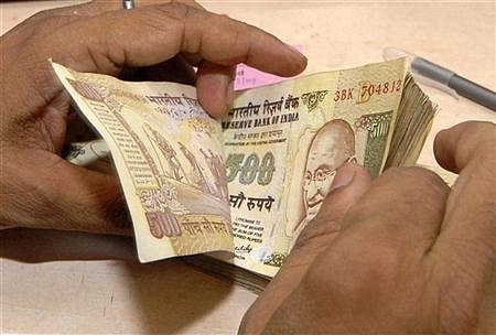 A bank official counts currency notes.