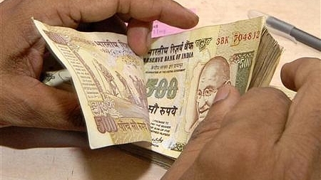 A bank official counts currency notes