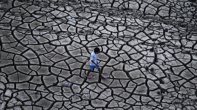 An Indian farmer walks on dry land in a drought-hit area. (Sanjay Kanojia/AFP/Getty Images)