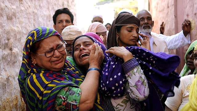 

In this photograph taken on September 29, 2015, relatives mourn slain Indian villager Mohammad Akhlaq in the village of Bisada, some 35 kilometres (22 miles) north-east of New Delhi, after his death at the hands of a mob in the northern state of Uttar Pradesh. Indian police said September 30, 2015, that they had arrested six people after a 50-year-old Muslim man was beaten to death over rumours he had eaten beef, a taboo in the Hindu-majority nation. Mohammad Akhlaq was dragged from his house on the outskirts of the Indian capital New Delhi and attacked by around 100 people late September 28, a police officer told AFP. (Photo credit: STRDEL/AFP/Getty Images)