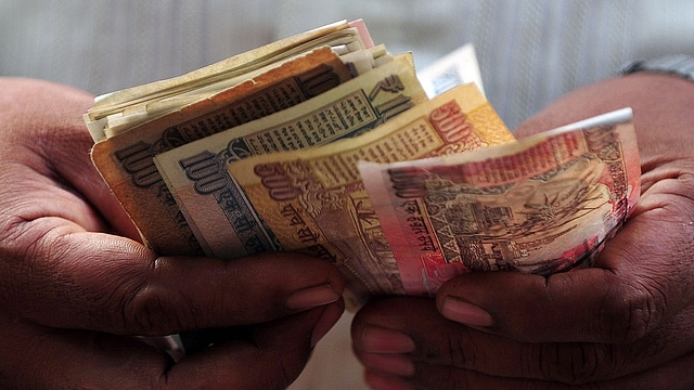 
A customer counts Indian rupee notes. (INDRANIL MUKHERJEE/AFP/Getty Images) 

