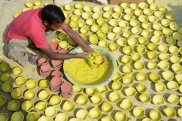 

A craftsman paints diyas  in Amritsar.