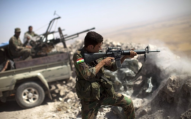 
An Iraqi Kurdish Peshmerga fighter fires at Islamic-State (IS) 
militant positions east of Mosul. (Photo By: JM LOPEZ/AFP/Getty 
Images)

