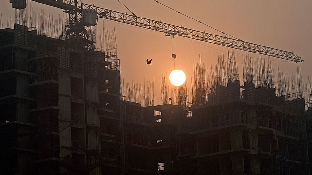 Sun rises over an under-construction apartment building on the outskirts of New Delhi. (PRAKASH SINGH/AFP/Getty Images)