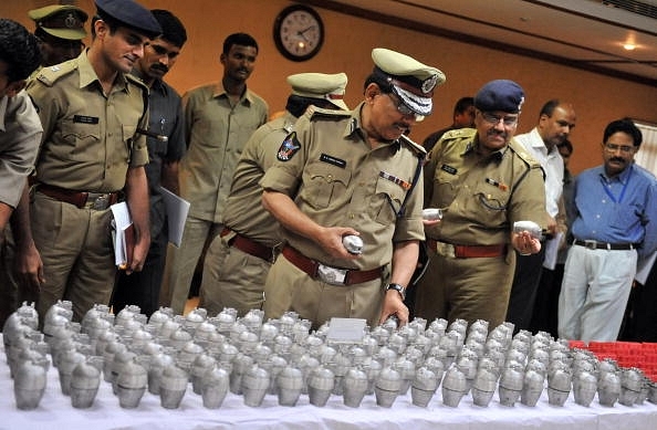 Police inspect seized weapons following an earlier encounter. 