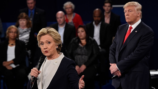 Republican nominee Donald Trump (R) watches Democratic nominee Hillary Clinton during the second presidential debate at Washington University in St. Louis, Missouri (SAUL LOEB/AFP/Getty Images)