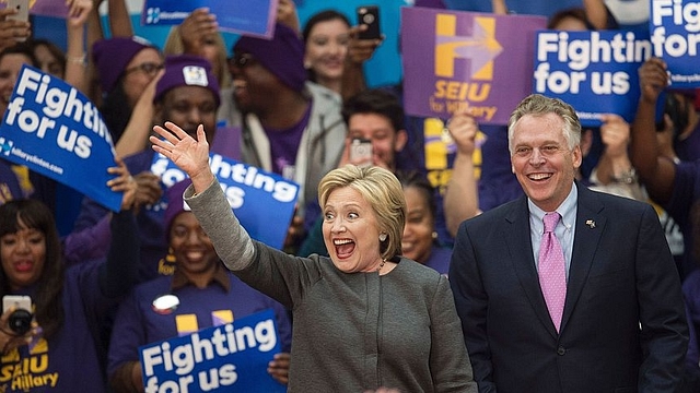 

Democratic presidential hopeful Hillary Clinton waves to the crowd beside Virginia Governor Terry McAuliffe during a campaign rally February 29, 2016 at George Mason University in Fairfax, Virginia (Photo credit: PAUL J. RICHARDS/AFP/Getty Images)