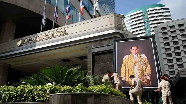 Workers lift a portrait of Thailand’s late King into position outside a hotel. (Leon Neal/Getty Images)