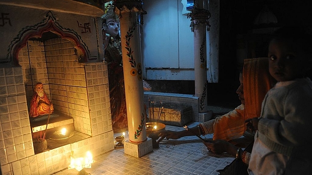 A Hindu woman devotee lighting a stick of incense on the altar of the Manher Mandir temple in Karachi. (Photo credit: RIZWAN TABASSUM/AFP/Getty Images