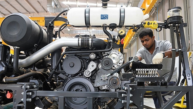 A worker assembles a bus at a manufacturing facility in Bengaluru. (MANJUNATH KIRAN/AFP/GettyImages