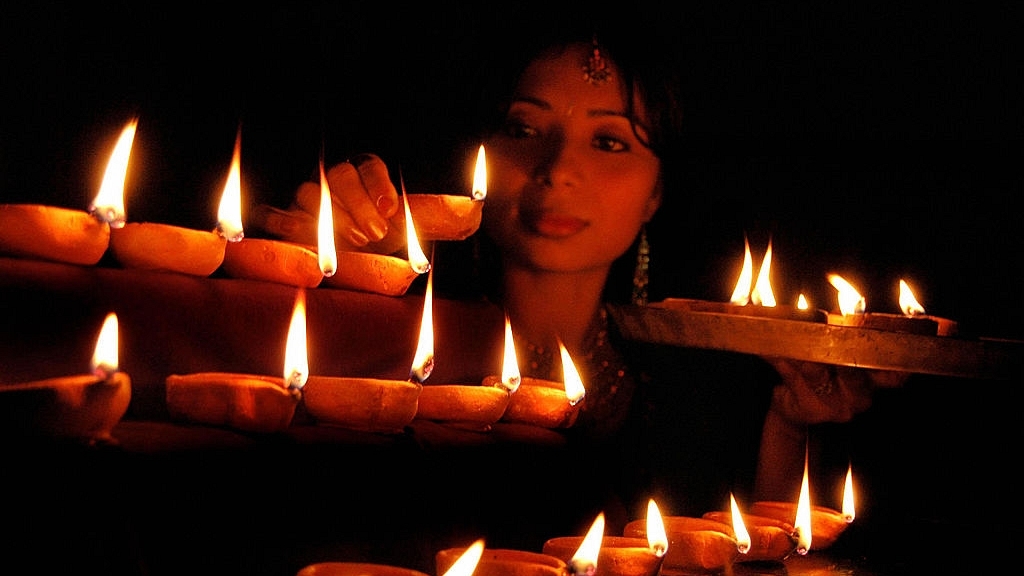 A woman lights lamps to mark Deepavali. Photo credit: STRDEL/AFP/GettyImages &nbsp; &nbsp; &nbsp;