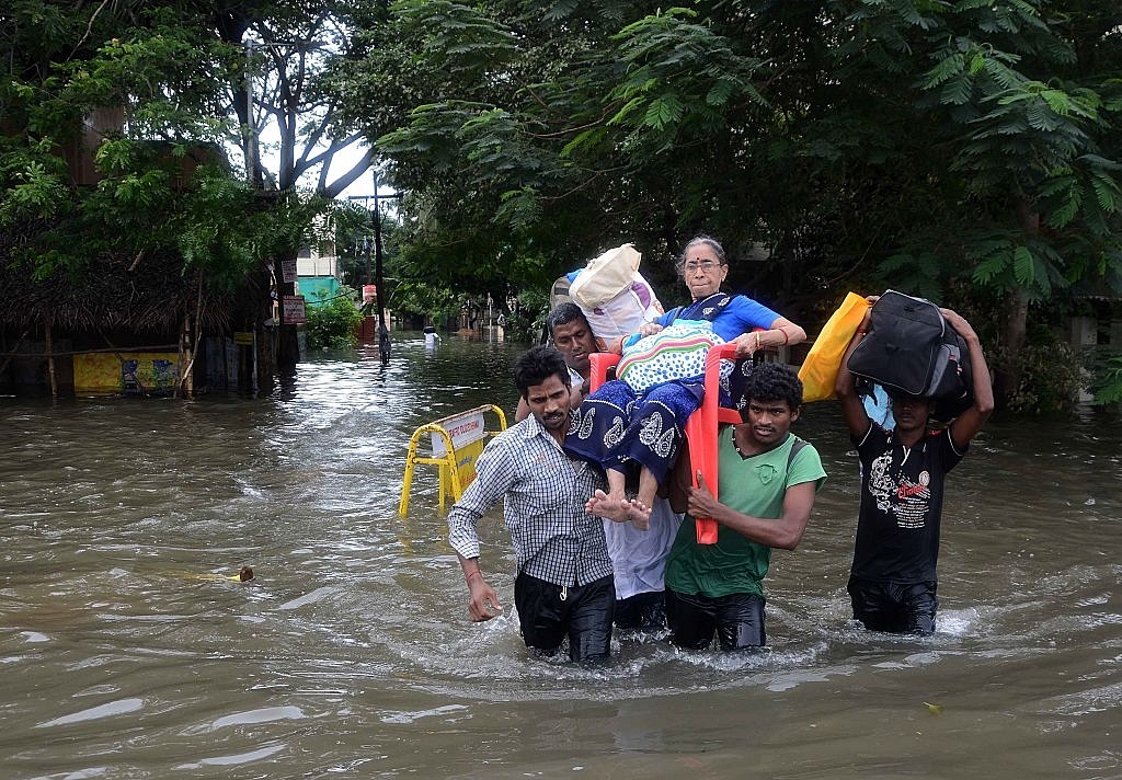 Indian men carry an elderly woman on a flooded street
following heavy rain in Chennai. Photo credit:  STR/AFP/GettyImages