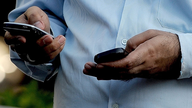 An Indian office-goer checks a text message on his mobile
phone in Mumbai. Photo credit: INDRANIL MUKHERJEE/AFP/GettyImages &nbsp; &nbsp; &nbsp;