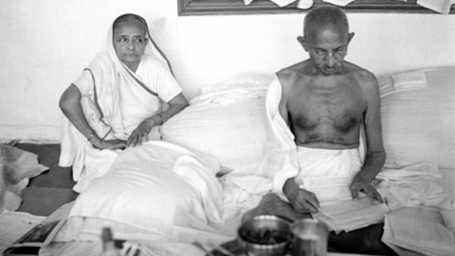 Kasturba watches as Gandhi reads&nbsp;