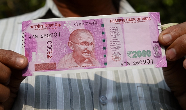 A man holds up a new Rs 2,000 note (SAJJAD HUSSAIN/AFP/Getty Images)