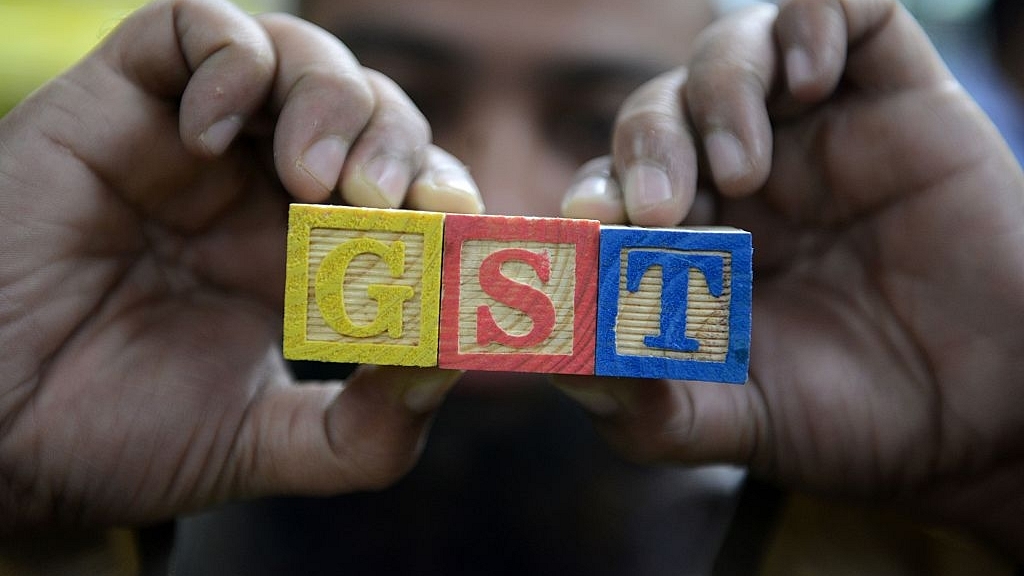 An Indian consumer goods trader shows letters GST representing ‘Goods and Services Tax’ (GST) (NOAH SEELAM/AFP/Getty Images)