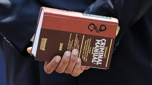 A lawyer holds a criminal manual (INDRANIL MUKHERJEE/AFP/Getty Images)