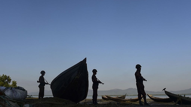 Border Guard Bangladesh (BGB) personnel watching for the illegal entry of Myanmar Rohingya refugees on the banks of the Naf River. Photo credit: MUNIR UZ ZAMAN/AFP/Getty Images