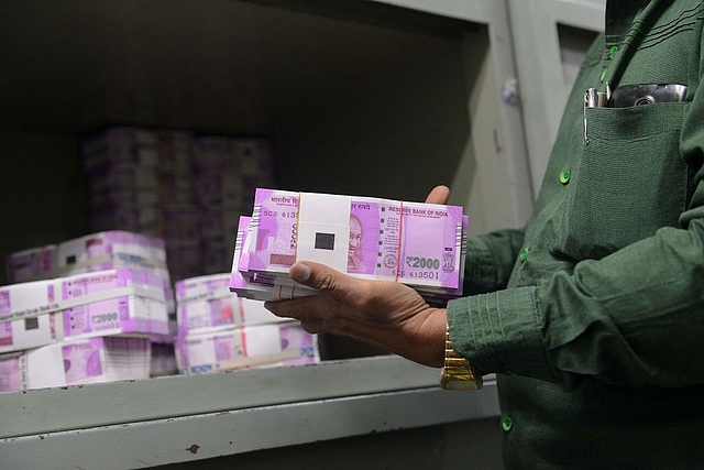 

Representational picture: An Indian bank employee checks stacks of new Rs2,000 rupee notes.  Photo credit: SAM PANTHAKY/AFP/GettyImages