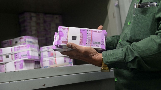 

An Indian bank employee checks stacks of new 2,000 rupee notes in Ahmedabad. Photo credit: SAM PANTHAKY/AFP/GettyImages