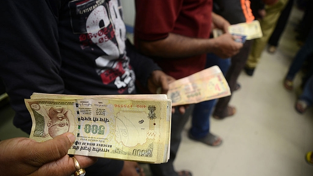 Indian residents queue to deposit money in a Cash Deposit Kiosk in Siliguri. (DIPTENDU DUTTA/AFP/Getty Images)