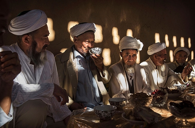  Uyghur men gather for a holiday meal during the Corban Festival  in the far western Xinjiang province, China. Photo credit: Kevin Frayer/Getty Images