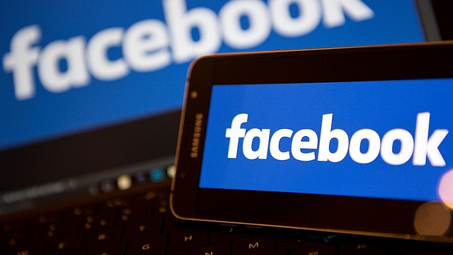 Facebook logos are pictured on the screens of a smartphone (R), and a laptop computer (Photo credit: JUSTIN TALLIS/AFP/Getty Images)