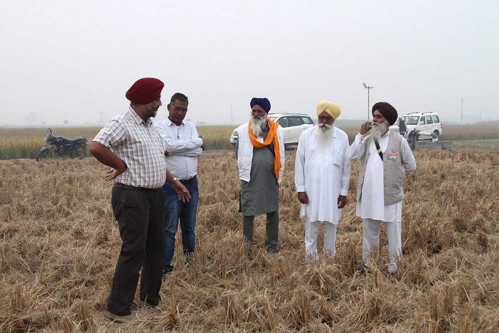 BISA Ludhiana station-in-charge H S Sidhu explaining conservation agriculture to elderly farmers. Photo by Vivian Fernandes