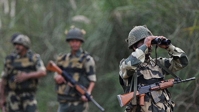 An Indian Border Security Force soldier looks through binoculars towards Pakistan. (TAUSEEF MUSTAFA/AFP/Getty Images)