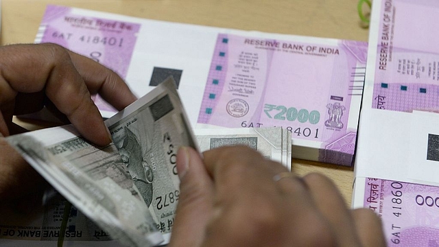 A bank staff member counts Indian 500 rupee notes to give to customers. (INDRANIL MUKHERJEE/AFP/Getty Images) 