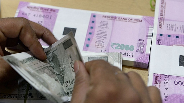 A bank staff member counts Indian 500 rupee notes to give to customers. (INDRANIL MUKHERJEE/AFP/Getty Images)&nbsp;