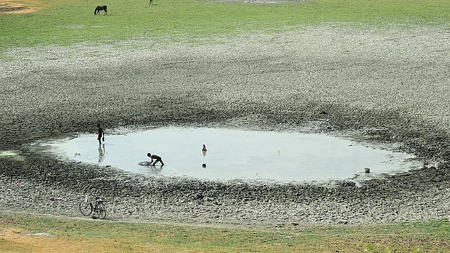 Indian fishermen catch fish in a shrunken pond. (Sanjay Kanojia/AFP/Getty Images)