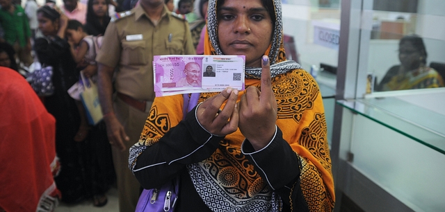 

A Indian woman poses with new 2000 rupee notes. (ARUN SANKAR/AFP/Getty Images)