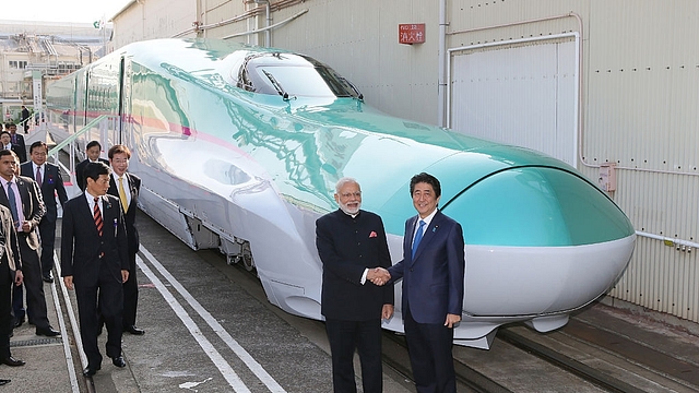 
Narendra Modi and Shinzo Abe shake hands in front of a Shinkansen train. (JIJI PRESS/AFP/Getty Images)

