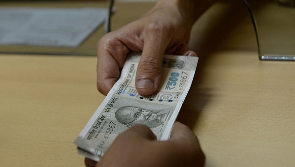 

A bank staff member hands Rs 500 notes to a customer on 24 November 2016. Photo credit: INDRANIL MUKHERJEE/AFP/GettyImages