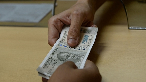 

A bank staff member hands Rs 500 notes to a customer. (INDRANIL MUKHERJEE/AFP/GettyImages)