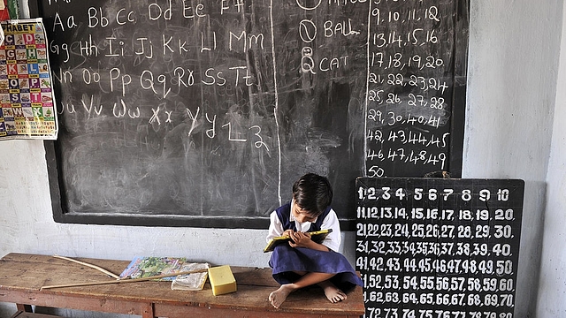 Indian school girl writes on a slate as she attends a government primary school in Hyderabad. Photo credit: NOAH SEELAM/AFP/Getty Images