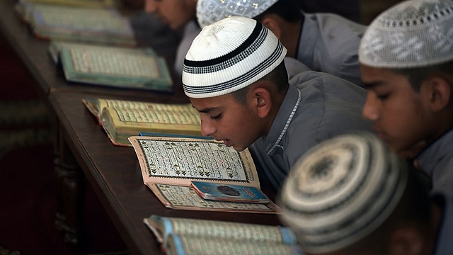 

Students of a madrassa recite the Quran at their seminary. Photo credit: AAMIR QURESHI/AFP/GettyImages