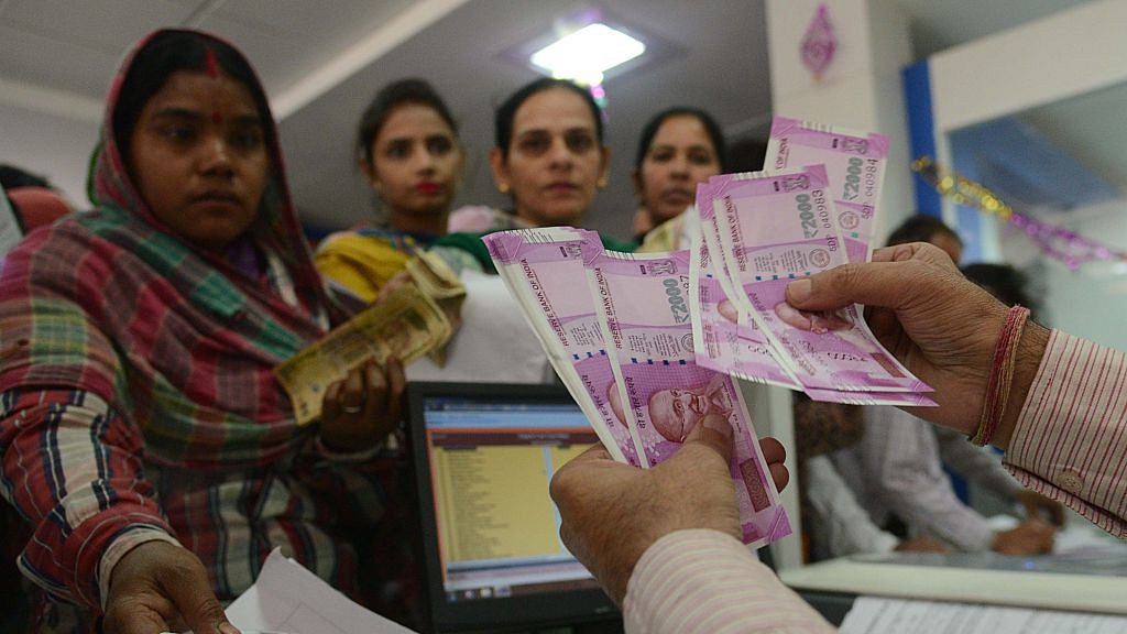 Customers at a bank counter exchanging old notes for new. (GettyImages)