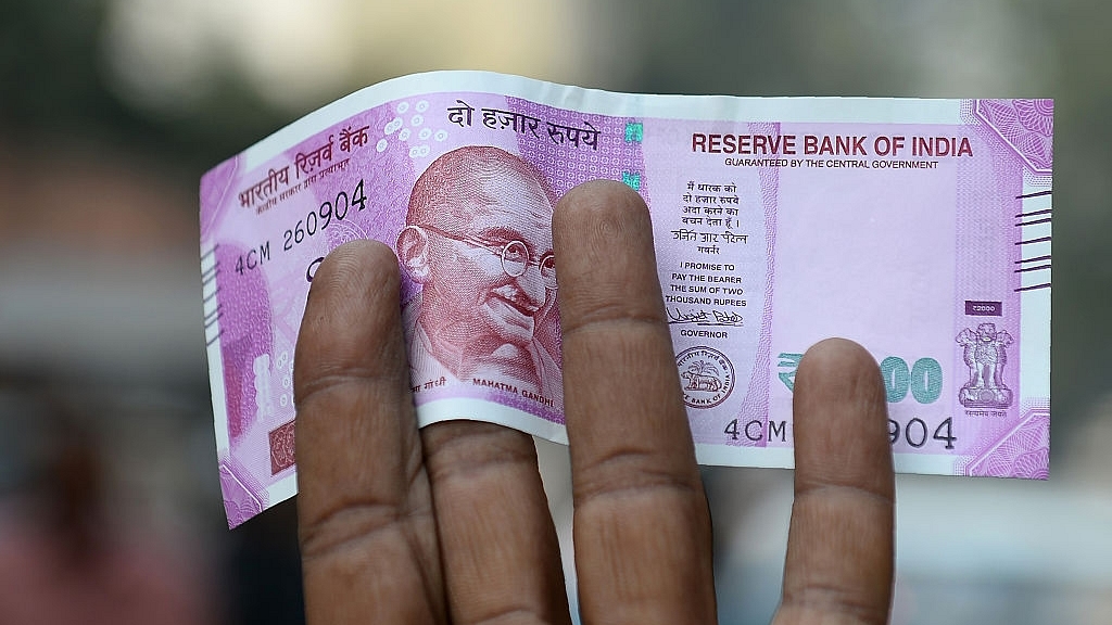 An Indian man displays a new Rs 2,000 note after exchanging his old Rs 500 and Rs 1,000 notes at a bank in New Delhi. (SAJJAD HUSSAIN/AFP/Getty Images) (representative picture)