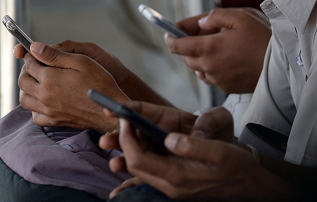 People check their mobile telephones at a free Wi-Fi Internet zone. (Photo credit: INDRANIL MUKHERJEE/AFP/Getty Images)