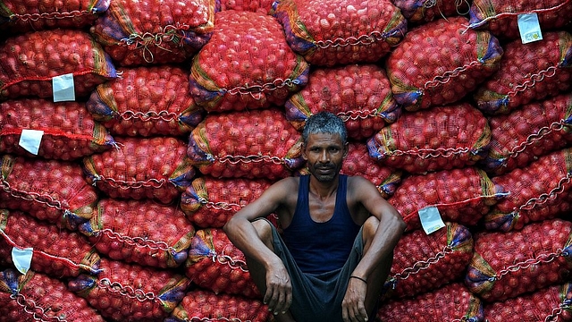 A labourer takes a break from unloading sacks of onions from a truck. (Sanjay Kanojia/AFP/Getty Images)