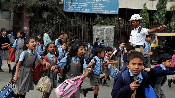 School children run
across a busy road as a traffic police stops the traffic in Bengaluru.
(DIBYANGSHU SARKAR/AFP/GettyImages) 