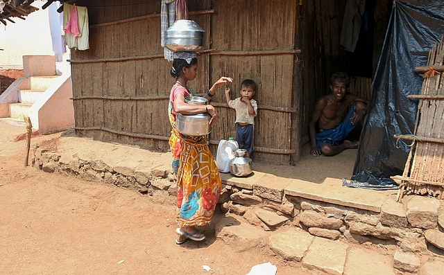 

An Indian villager carries containers home after collecting a supply of potable water from a well following a tanker’s daily delivery in Shahapur, some 130 kms southwest of Mumbai.(INDRANIL MUKHERJEE/AFP/GettyImages)