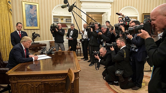 President Donald Trump signs his first executive order as president, ordering federal agencies to ease the burden of the Affordable Care Act. (Kevin Dietsch - Pool/Getty Images)