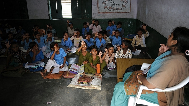 Indian school children read in a classroom at a government school in Bagpath district in Uttar Pradesh. (SAJJAD HUSSAIN/AFP/Getty Images)