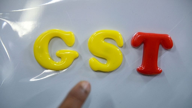 An Indian consumer goods trader shows letters GST at his shop in
Hyderabad.(NOAH SEELAM/AFP/GettyImages)